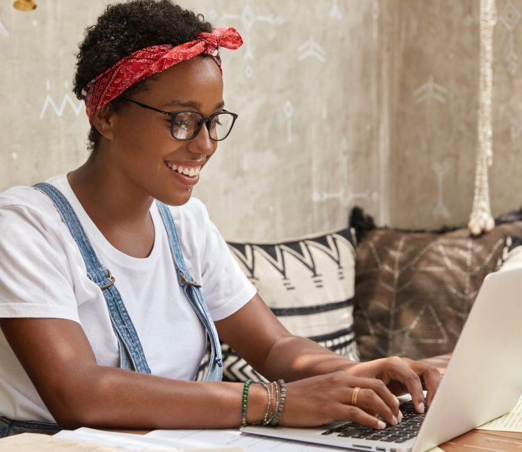 Nigeria girl typing on laptop with smile